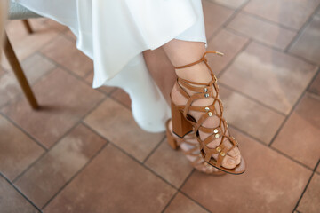 Sandals Heels Wedding: Woman wears leather sandal heels with white dress indoors during formal...