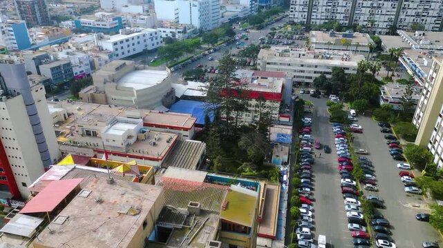 Vista aerea de un barrio Lime&ntilde;o y una bandera peruana ondeando en el techo de un edificio.