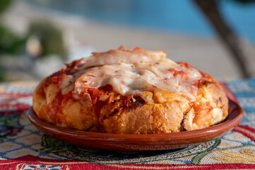 Fresh baked bread, pizza, focaccia or pala romana pizza with tomatoes, vegetables and cheese, street food in Palermo, Sicily, Italy, view on Mondello beach