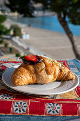 Italian breakfast, fresh baked butter croissant filled with ricotta cheese and jam, served outdoor...