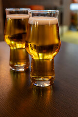 Freshly brewed light pils German beer in craft brewery served in beer glass poured from keg