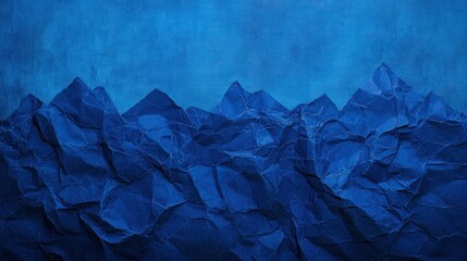 Naklejka premium Crinkled paper mountains against a deep blue sky