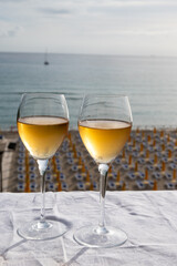 Celebration, birthday party, pouring of sweet muscat white wine from Pantelleria island on holiday on Mondello beach, Palermo, Sicily, Italy