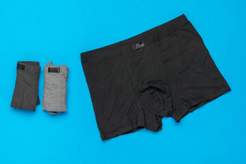 Men's Underwear Set: Black Boxer Briefs and Gray Crew Socks on Blue Background
