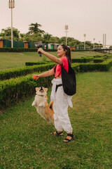 Young girl with Corgi recording video on phone share via app her travel vacation. Gen Z influencer...