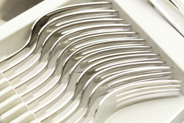 Set of silver metal forks arranged in drawer tray. Shiny stainless steel cutlery in organized...