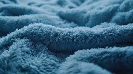 Fototapeta premium Soft blue blanket draped on a cozy bed creating a warm atmosphere in a relaxing space