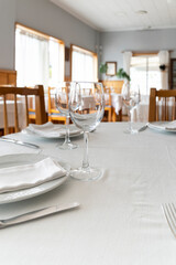 Wine glasses and plates are set on a table in a restaurant dining room, creating an elegant atmosphere