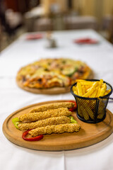 Delicious Fried Chicken Sticks, Fries, and Pizza Capricciosa