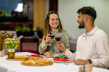 Young Couple Enjoying Red Wine and Delicious Food on Date