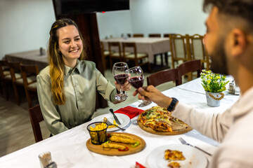 Young Couple Toasting with Red Wine Before Dinner