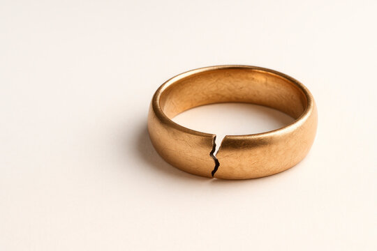 A broken wedding ring, a symbol of the end of the union. Space for text.