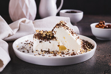 Ice cream sprinkled with chocolate chips and nuts on a plate on the table