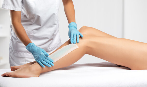 A beautician makes a depilation of a woman's body in a beauty salon. Female aesthetic cosmetology.