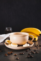 Alternative cold banana coffee in a cup on the table vertical view