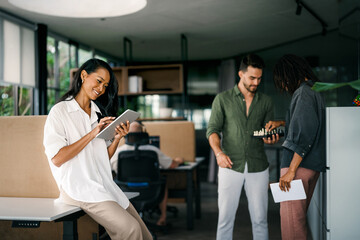 Diverse team of two business people working talking using tablet tech walking in corporate office.
