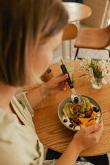 Close-up of female hands holding a plate. Granola with fresh fruit and yoghurt. A healthy natural...