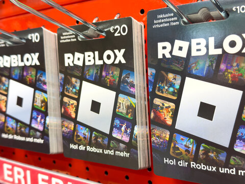 Villach, Austria - July 10, 2025: Roblox gift cards displayed on a vibrant red shelf, showcasing various values and colorful game artwork, perfect for gaming enthusiasts and virtual currency purchases