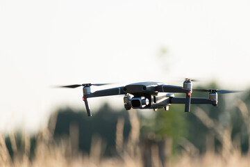 Close-up view of drone flying over agricultural field in spring, Quadcopter in flight over autumn field, Drone quadcopter with a camera hovered over a wheat field