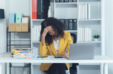 Stressed Office Woman at her Desk: A woman grappling with work-related challenges, head resting on...