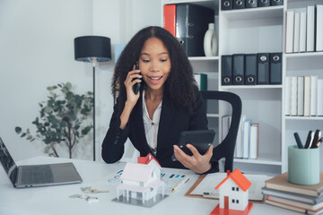 Real Estate Agent in Action: A young real estate agent is deeply engrossed in a phone conversation,...