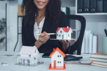 Real Estate Presentation: A professional showcases miniature houses, expertly presenting property...