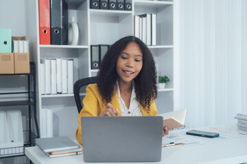 Focused Professional in the Office: A dedicated business professional, sits at her desk engrossed...