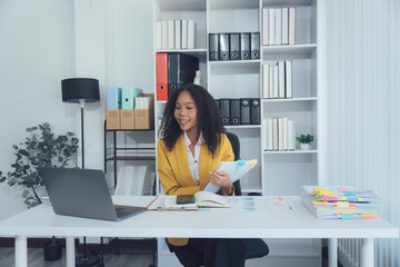 Focused Professional: An elegant woman, absorbed in work, sits poised at a modern desk, creating a...