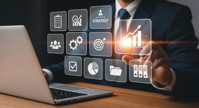 A business man interacting with digital icons near a laptop on a wooden office desk surface - Powered by Adobe