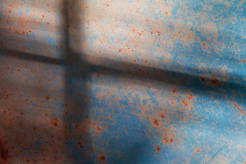 Macro of rust spots on weathered blue painted metal, forming an abstract textured pattern with...