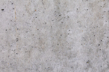 Close-up of raw unfinished concrete wall with holes and grain, suitable for use as texture, background, or graphic design overlay