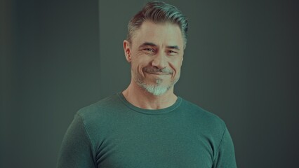 Portrait of happy confident mid adult man in smiling. Gray hair, bearded middle aged male looking...
