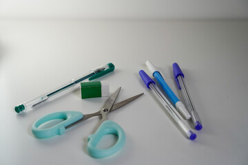 Top view of blue pens and pencils on light background, office and school supplies