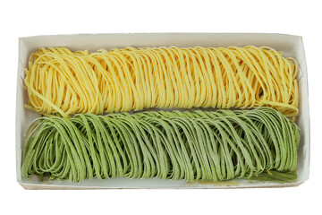 Various of uncooked pasta. Top view. Egg and spinach tagliatelle on box isolated on white background.