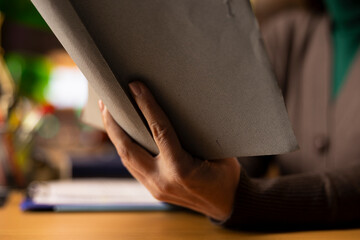 Mature person immersed in reading and researching at campus library, working on her diploma...