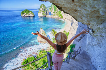 Traveler woman enjoying of amazing landscape of scenic way to Diamond beach during vacation to Nusa...