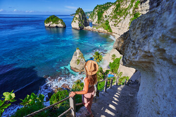 Traveler woman enjoying of amazing landscape of scenic way to Diamond beach during vacation to Nusa...