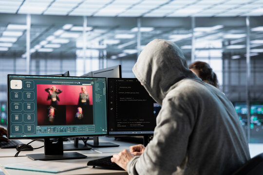 System administrator in server hub coding AI program turning text prompt into photos. Hooded man in data center using computer to build text to image artificial intelligence generative models