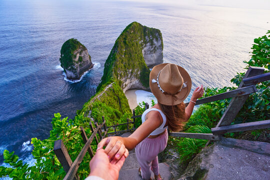 Follow me to scenic Kelingking beach. Traveling couple on vacation journey holiday to Nusa Penida Island in Indonesia, explore and travel to touristic beautiful destinations, honeymoon together