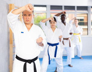 Kata karate teacher conducts classes and performs movements and fighting techniques together with...