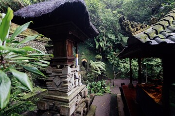 Balinese Hindu shrines stand in a lush, green temple courtyard in Ubud, Bali, Indonesia. The...