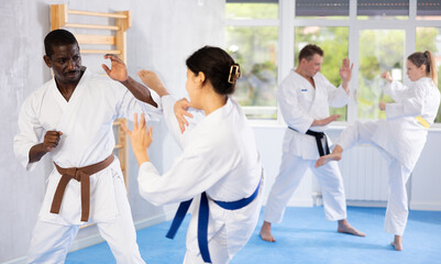 Irate middle-aged male karate practitioner fighting with his opponent in sports hall © JackF