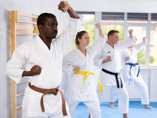 Kata karate teacher conducts classes and performs movements and fighting techniques together with...