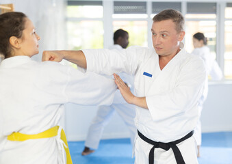 In gym, cosmopolite athletes work in pairs and learn to use classic karate techniques to repel an...