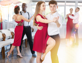 Naklejka premium Young man and young woman dance couple tango dance in studio