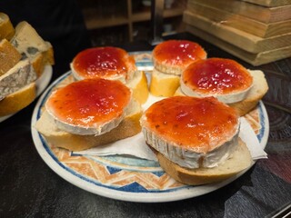 Gourmet cheese and jam appetizer on sliced bread for entertaining and dining. Bar in Spain. Spanish...