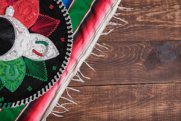 Serape and Mexican hat on wooden table. Mexican background.