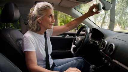 Caucasian mature satisfied elderly woman senior lady female automobile taxi driver pensioner inside...