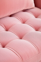 Fototapeta premium A close-up of a luxurious pink tufted fabric with a cushioned texture. Elegant interior design element