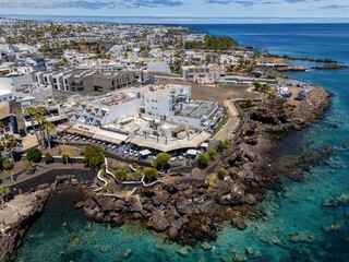 Aerial view of Puerto del Carmen, Lanzarote, showcasing coastal buildings and clear blue waters